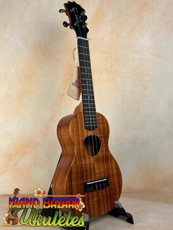 Wooden ukulele with dark grain patterns and black pegs, featuring KoAloha Royal Pikake KCM-00RP