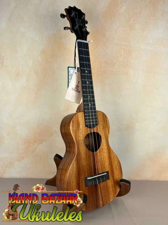 Wooden KoAloha Royal Pikake Concert Ukulele with dark fretboard on display stand