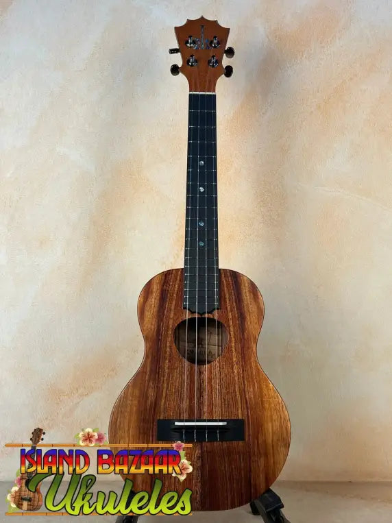 Wooden ukulele with dark fretboard and natural grain, Koaloha Royal Pikake Tenor