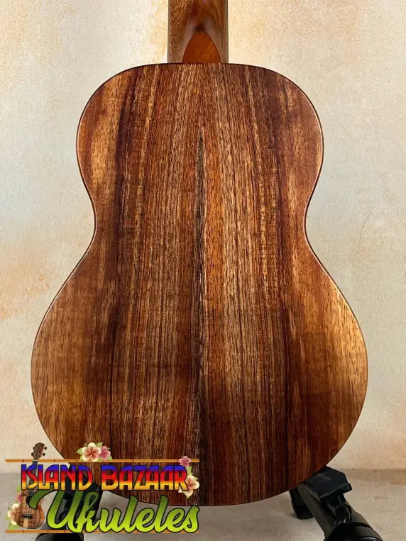 Wooden acoustic guitar with rich brown grain patterns, showcasing Koaloha Royal Pikake