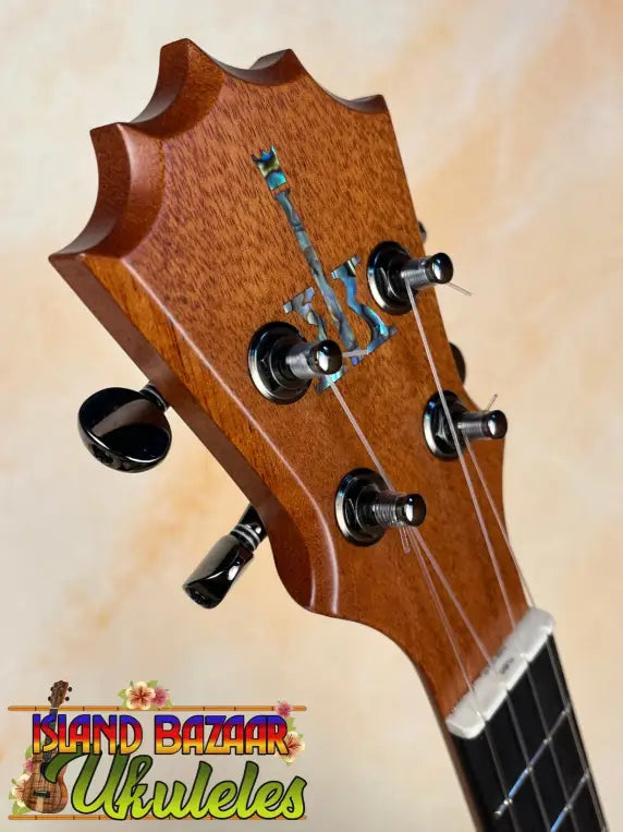 Wooden guitar headstock of Koaloha Royal Pikake Tenor Ukulele with black tuning pegs