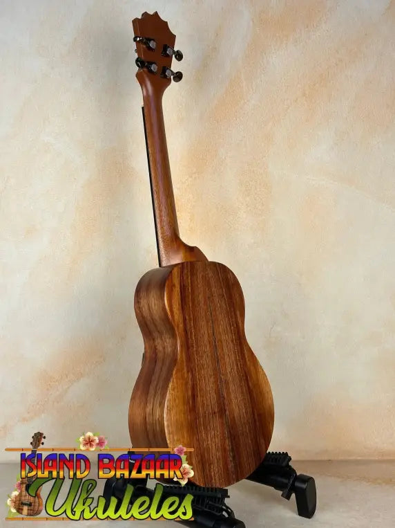 Wooden Koaloha Royal Pikake Tenor Ukulele on a black stand with satin-finish koa