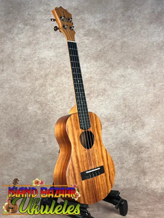 Light brown wooden Koaloha Tenor Hawaiian ukulele with matte finish and black tuning pegs