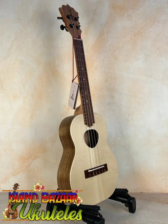 Natural wood KoAloha Tenor Opio Solid Spruce/Solid Acacia Ukulele on black stand