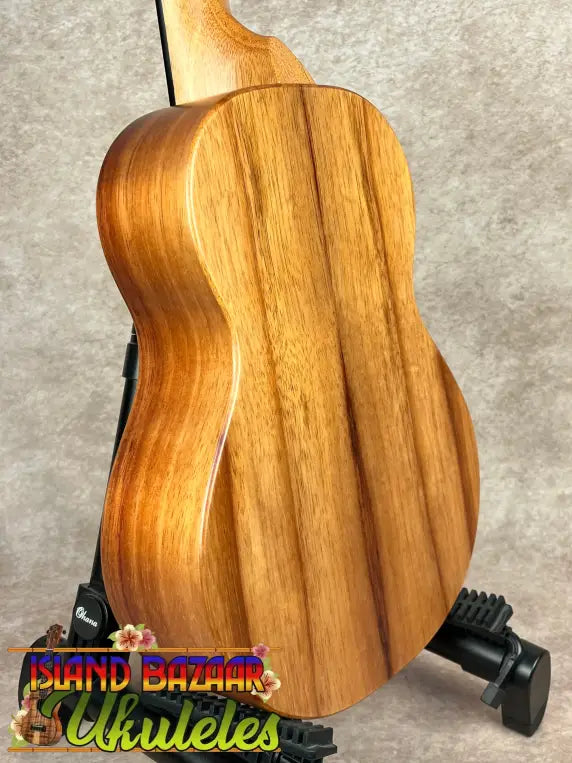 Back of koaloha royal pikake tenor ukulele in matte finish on black stand with solid Hawaiian koa