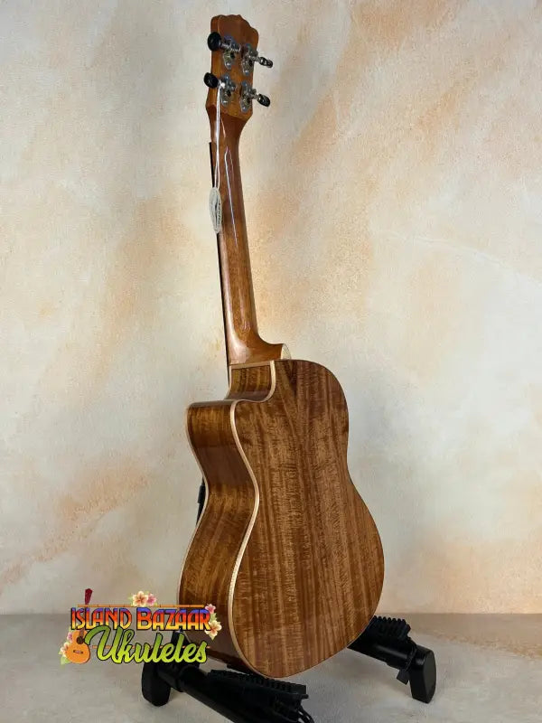 Wooden acoustic guitar on black stand showcasing Luna Vista Deer Tenor Electric Ukulele