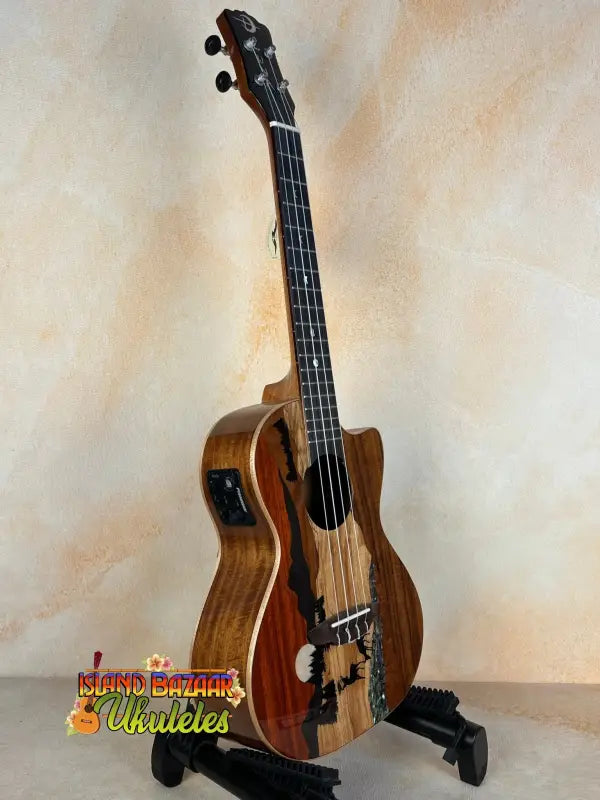 Electric-acoustic Luna Vista Deer Tenor Ukulele with decorative wood patterns on stand