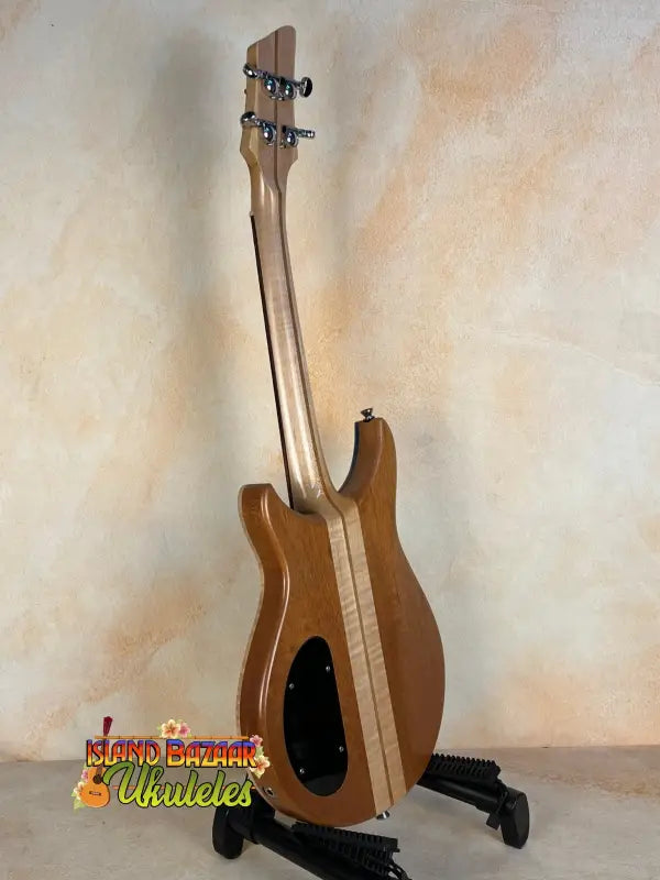 Wooden bass guitar on a black stand for Mann Electric Tenor Ukulele Solid Body