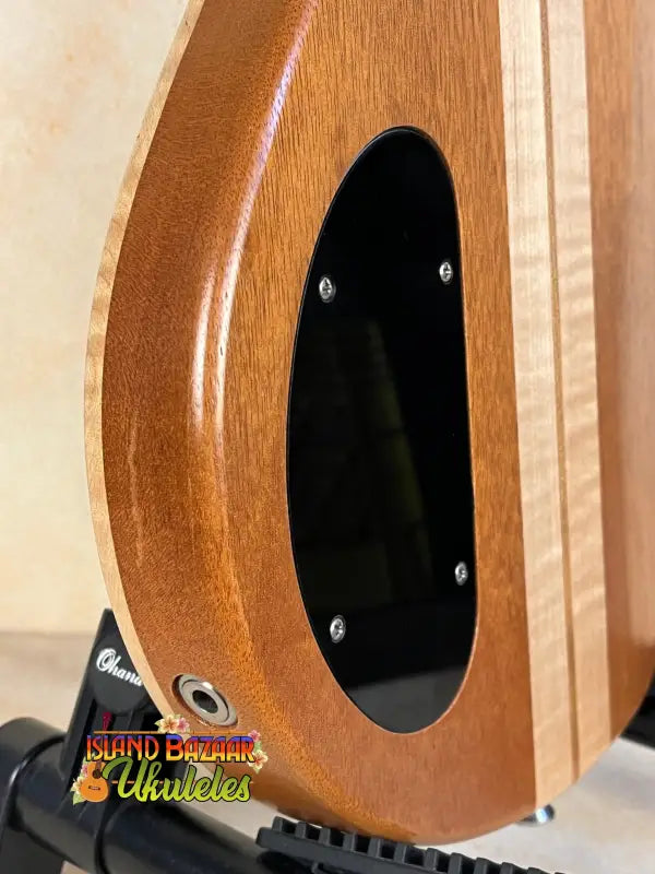 Wooden guitar body of Mann Electric Tenor Ukulele with oval sound hole and screws