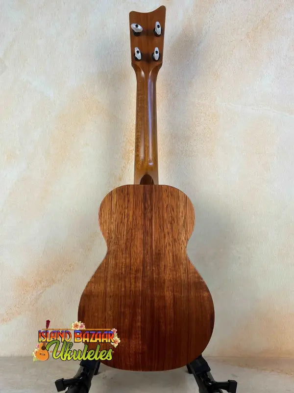 Wooden Kamaka Concert Ukulele HF-2 in solid koa resting on a black stand