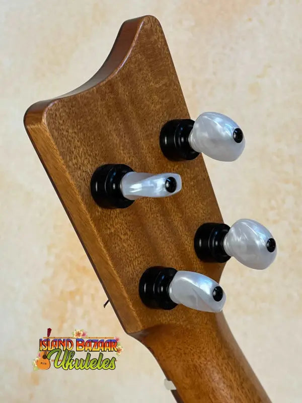 Guitar headstock of Kamaka HF-2 Ukulele with black and white tuners on solid koa wood