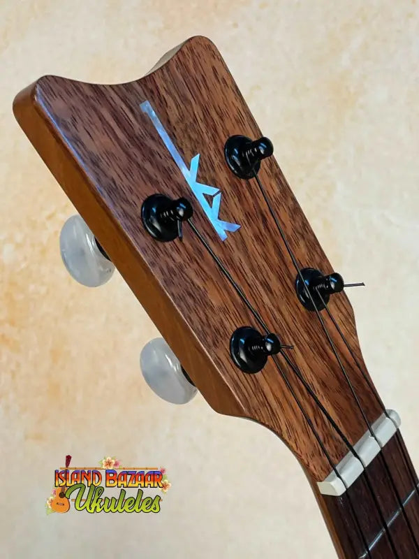 Wooden ukulele headstock with black tuning pegs and blue arrow on Kamaka HF-2 Ukulele