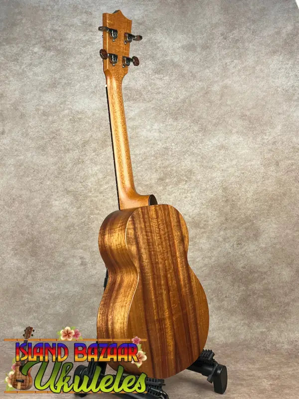 Wooden Kamaka HF-3 Tenor Ukulele on stand showcasing its solid Koa craftsmanship