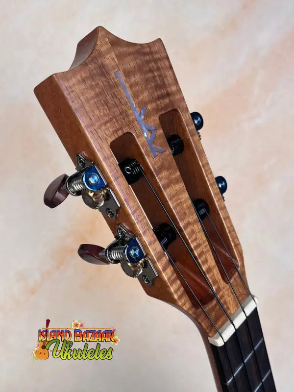 Guitar headstock of Kamaka HF-3I Slothead Tenor Ukulele with figured maple wood and blue pegs
