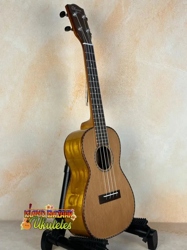 Natural wood tenor ukulele on a black stand showcasing Ohana CK-50WG Concert design