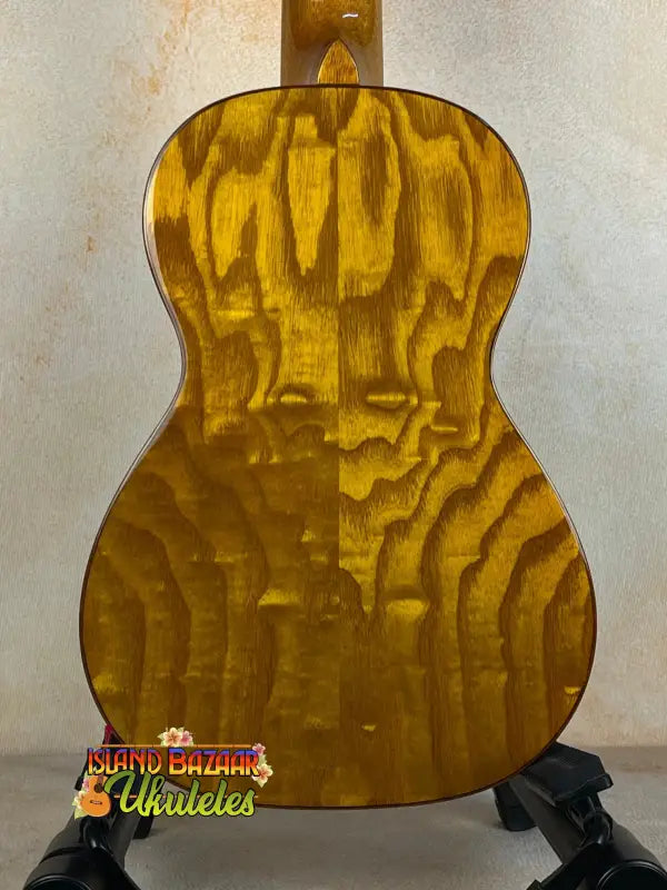 Golden acoustic guitar with rippled wood grain, showcasing Ohana CK-50WG Concert Ukulele