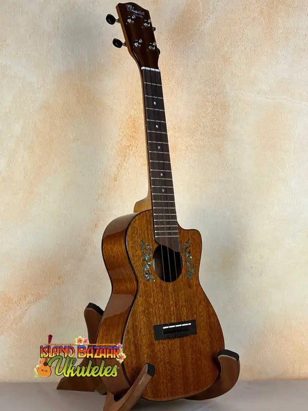 Wooden ukulele with natural finish on stand, Ohana CK-60CG Mahogany Concert Ukulele