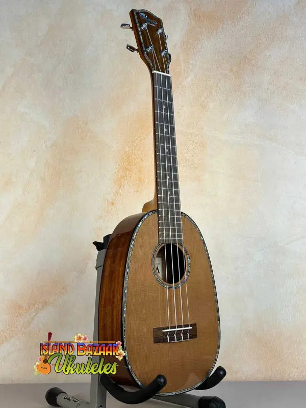 Pineapple-shaped ukulele on stand, showcasing Ohana PKC-50G Solid Cedar & Mahogany design