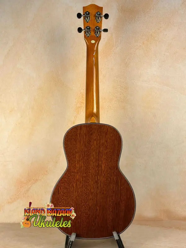 Wooden acoustic guitar with natural finish on display, Ohana TK-35G Solid Mahogany Tenor