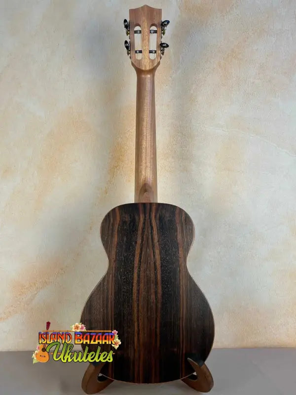 Acoustic guitar with dark striped wood grain back of Ohana TK-50ME Solid Cedar Tenor Ukulele