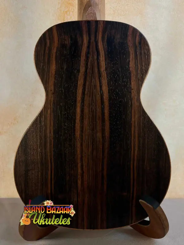 Acoustic guitar with dark striped wood grain, showcasing Ohana TK-50ME Solid Cedar Top