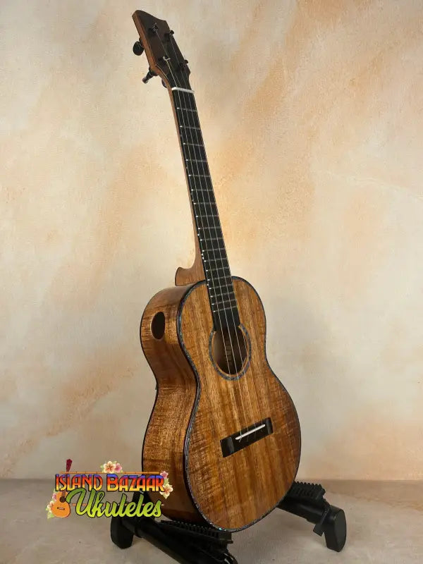 Brown wooden tenor ukulele on stand from PCH Sunshine Phil Henderson with solid Hawaiian koa