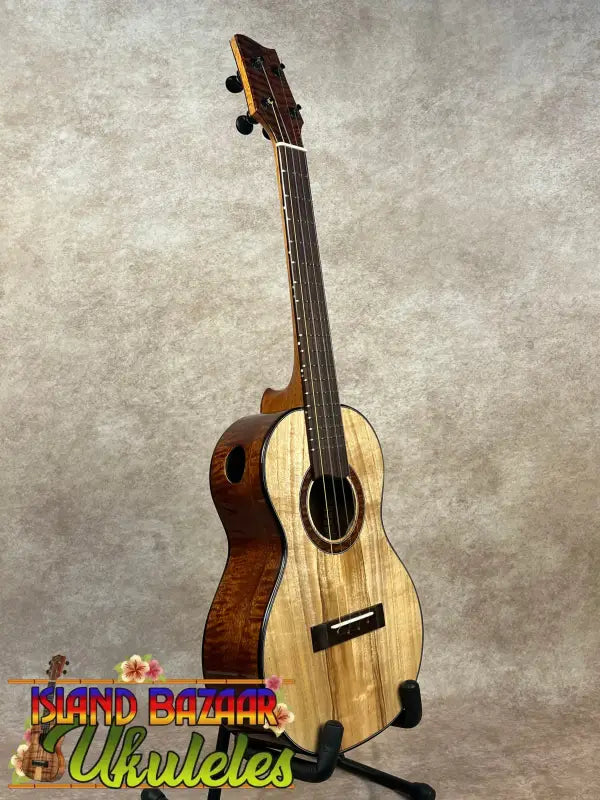 Wooden ukulele on stand from Phil Henderson showcasing the Ladder PCH Tenor Ukulele