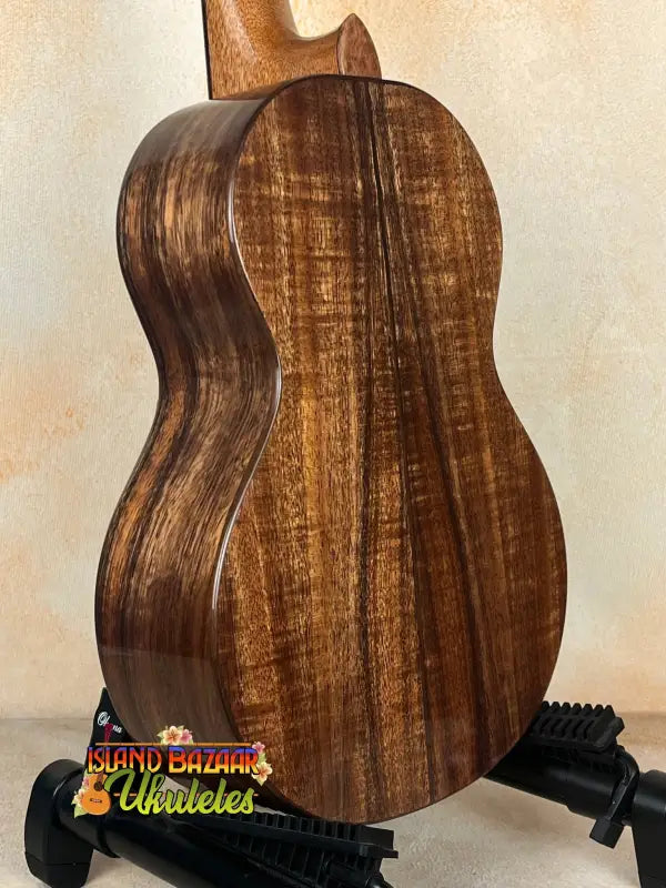 Wooden acoustic guitar featuring rich brown koa wood grain in Phil Henderson Ukuleles Chocolate Thunder Solid Koa Tenor