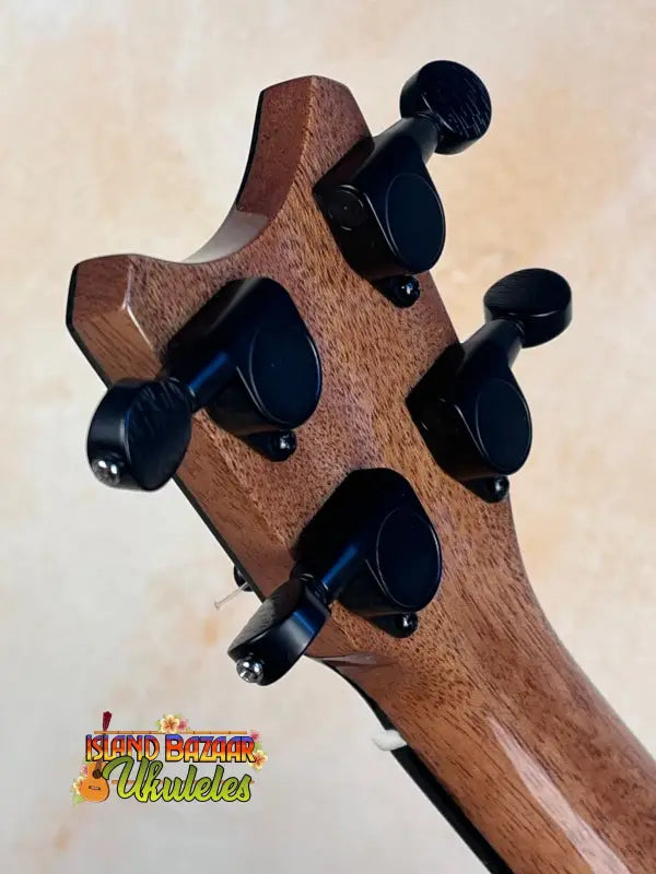 Bass guitar headstock with black tuning pegs on Romero Creations Tiny Tenor in Spalted Mango