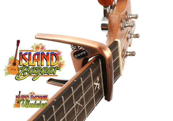 Guitar capo attached to fretboard with Island Breeze branding for Swiff Ukulele K8-U