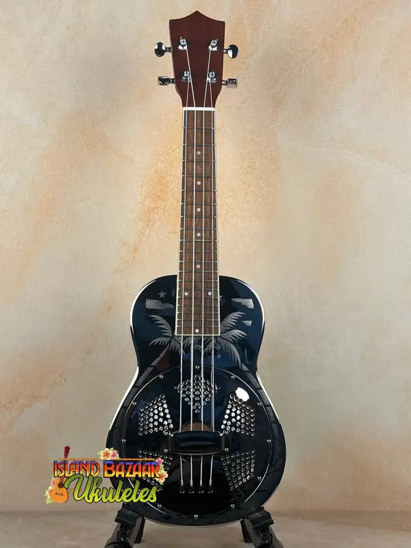 Black resonator concert ukulele with palm tree design in the Tradewinds Resonator Concert series