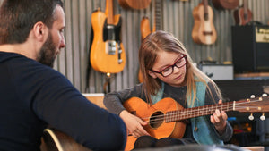 Young girl learning ukulele with instructor at Island Bazaar Ukes music lesson studio – beginner ukulele class for kids