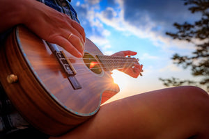 close-up of a mahogany soprano ukulele on wood background – best ukulele for beginners with warm tone