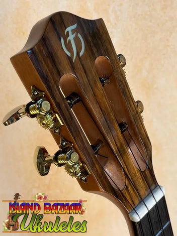 Colorful Flight Ukuleles including tenor electric ukulele lined on a leather couch.