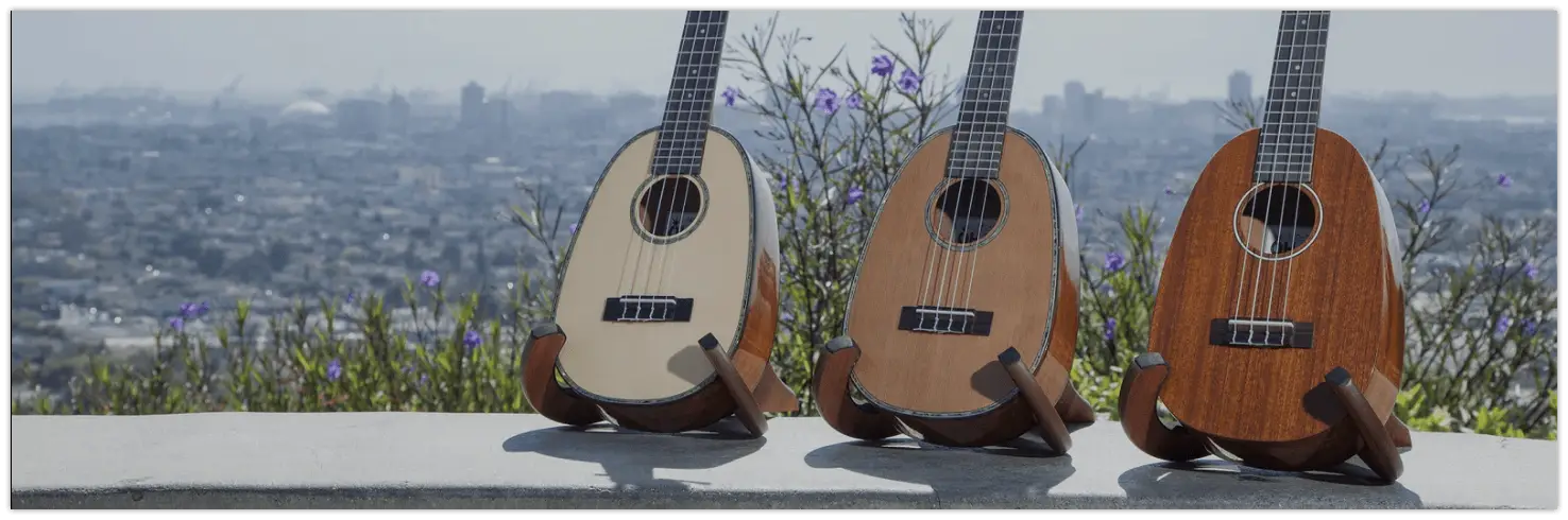 Three Ohana Ukuleles featuring solid cedar and cedar & rosewood lined up on a ledge.