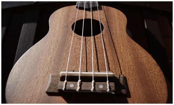 Satin Mahogany Baritone Ukulele showcasing four strings and a bridge at Island Bazaar.