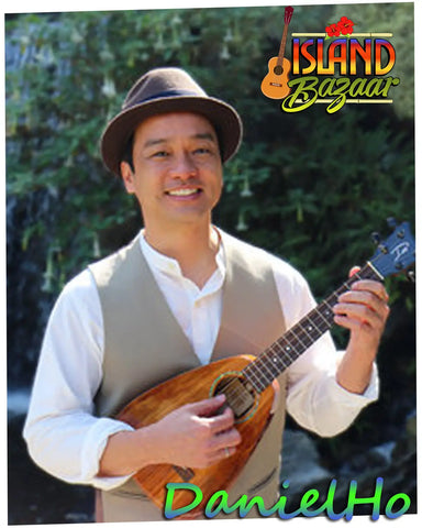 Musician in fedora and vest playing ukulele at Friends of The Island Bazaar online shop.