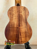 Wooden acoustic guitar with rich koa grain showcased with Kamaka Soprano Ukulele HF-1