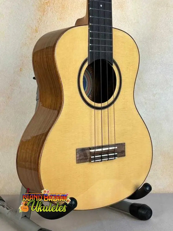 Natural wood Flight Sophia Soundwave Tenor Uke on a black stand with gig bag