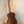 Wooden ukulele with rich brown finish on stand, part of Flight Voyager Tenor series