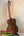 Wooden ukulele with rich brown finish on stand, part of Flight Voyager Tenor series