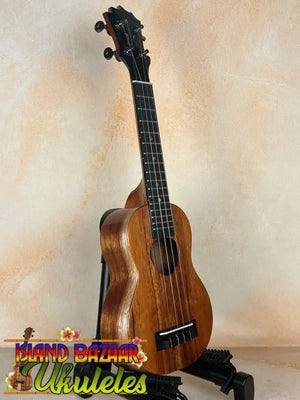 Wooden ukulele on black stand showcasing the Exquisite KoAloha KSM-00 Soprano Ukulele