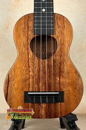 Exquisite KoAloha KSM-00 Soprano Ukulele with dark grain and black fretboard on stand