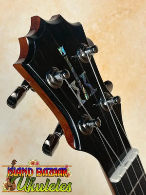 Guitar headstock with black tuning pegs and strings on KoAloha KSM-00 Soprano Ukulele