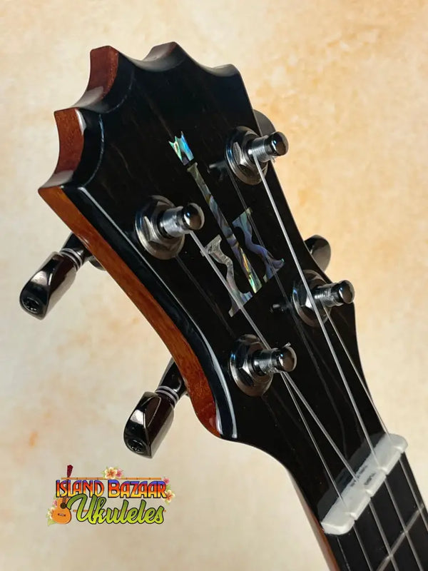 Guitar headstock with black tuning pegs and strings on KoAloha KSM-00 Soprano Ukulele