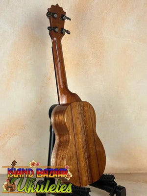 Wooden KoAloha KSM-00 Soprano Ukulele with rich brown grain on black stand