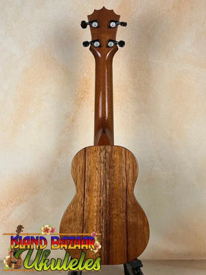 Wooden ukulele with grain and black pegs, featuring the Exquisite KoAloha KSM-00 Soprano Ukulele