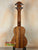 Wooden ukulele with grain and black pegs, featuring the Exquisite KoAloha KSM-00 Soprano Ukulele