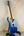 Blue and white Flight Pathfinder Tenor Electric Ukulele on a stand with maple neck