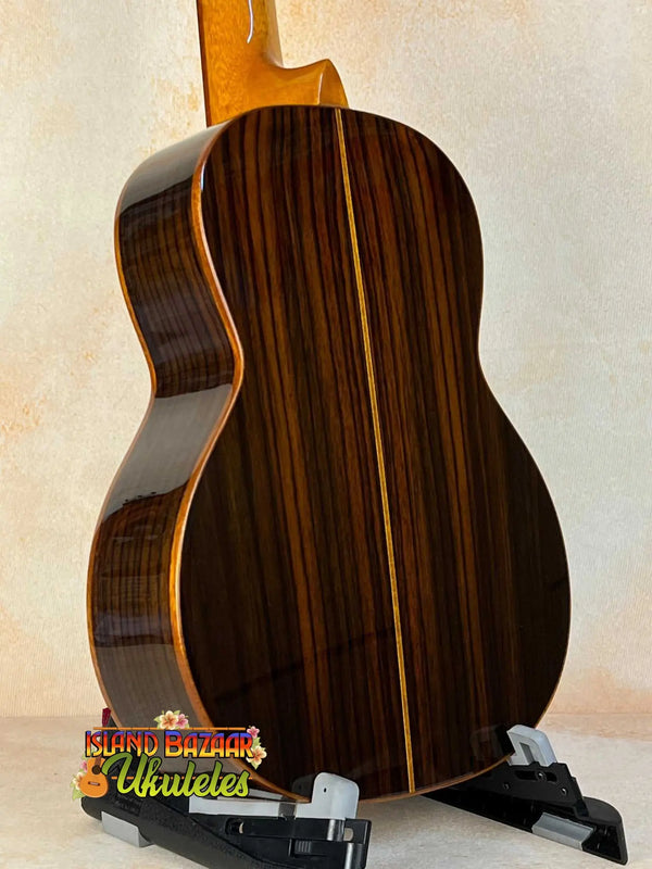 Classical acoustic guitar featuring dark striped wood back and sides with Ohana TK-50G